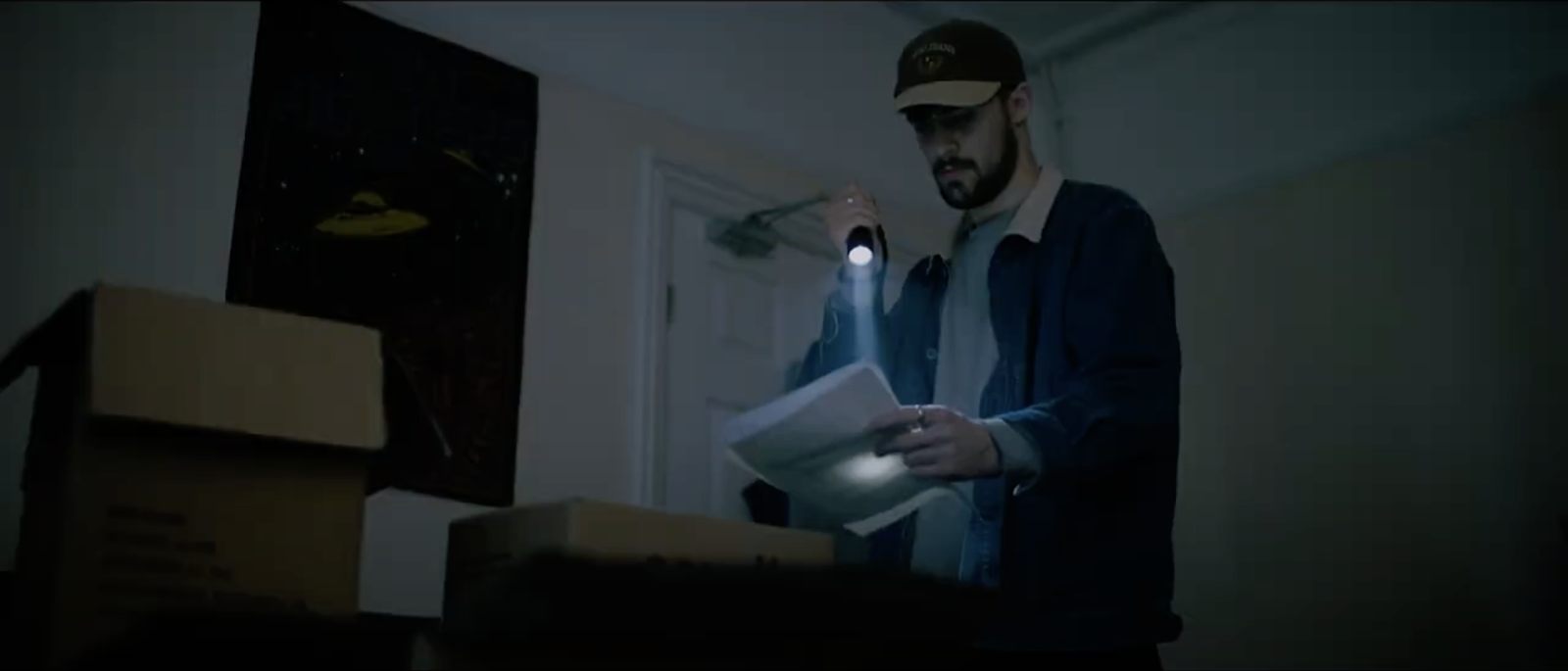 A man reading papers by torchlight in Nature’s Mockery